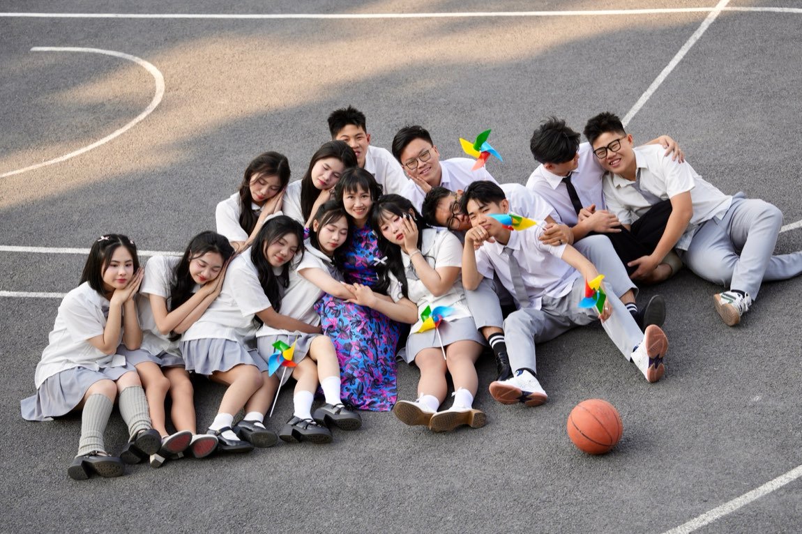 Students resting their heads on each other in a seated pile