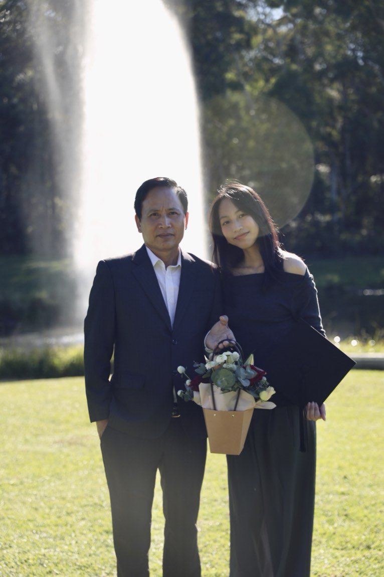 Father and daughter backlit by a fountain