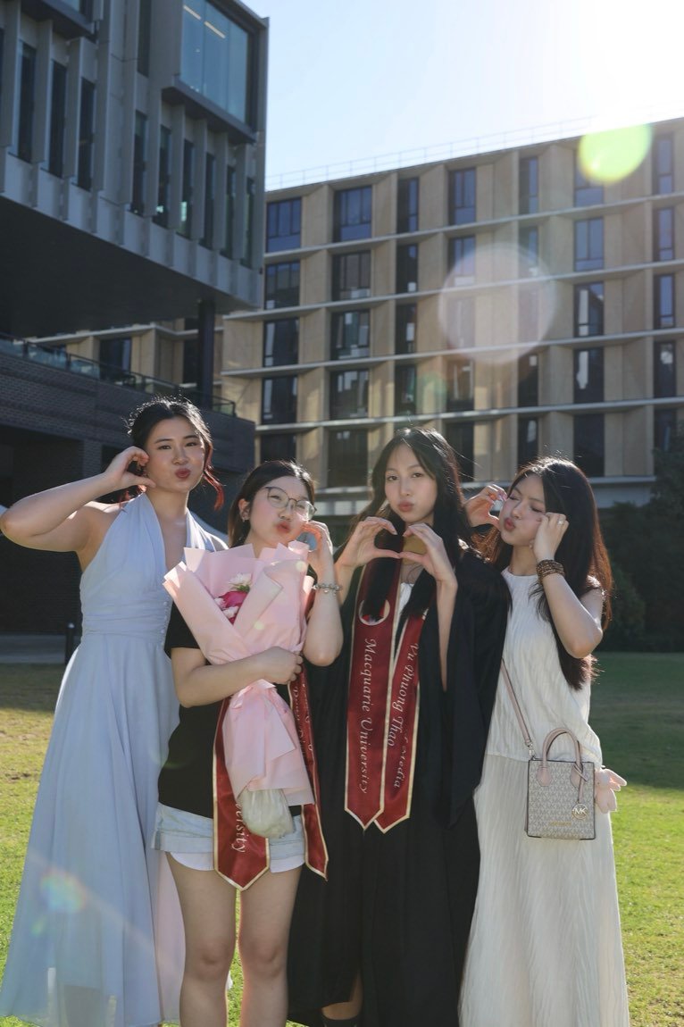 Four friends posing together on the campus lawn